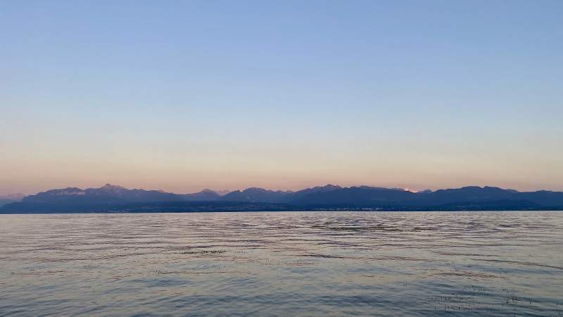 The Alps turning pink before sunset with the lake in front