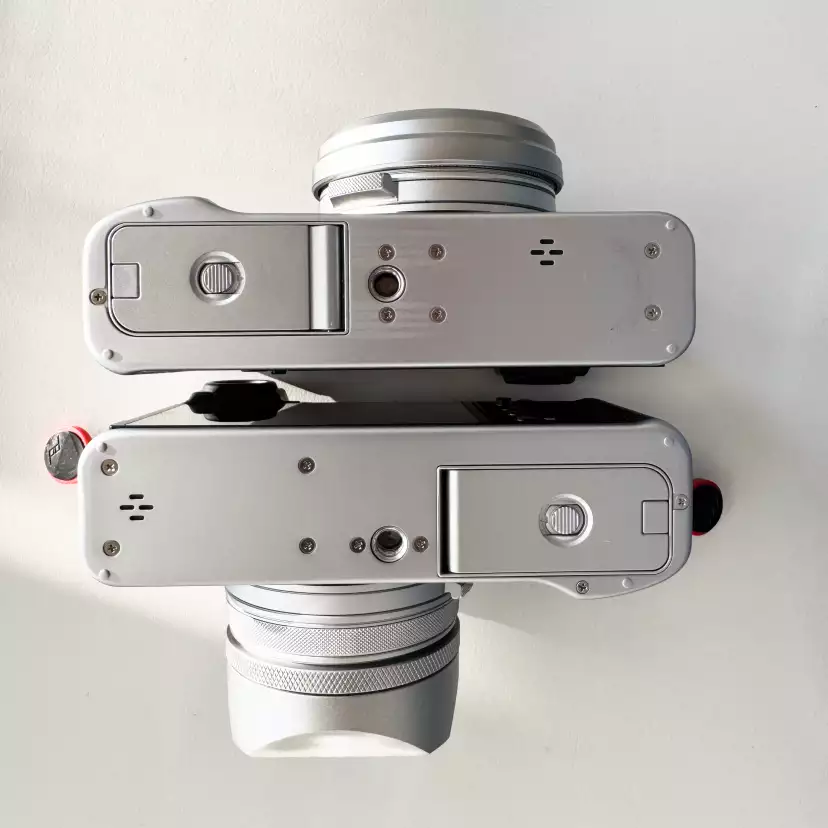 Fujifilm X100V and X100VI bottom back to back showing the different location of the tripod thread
