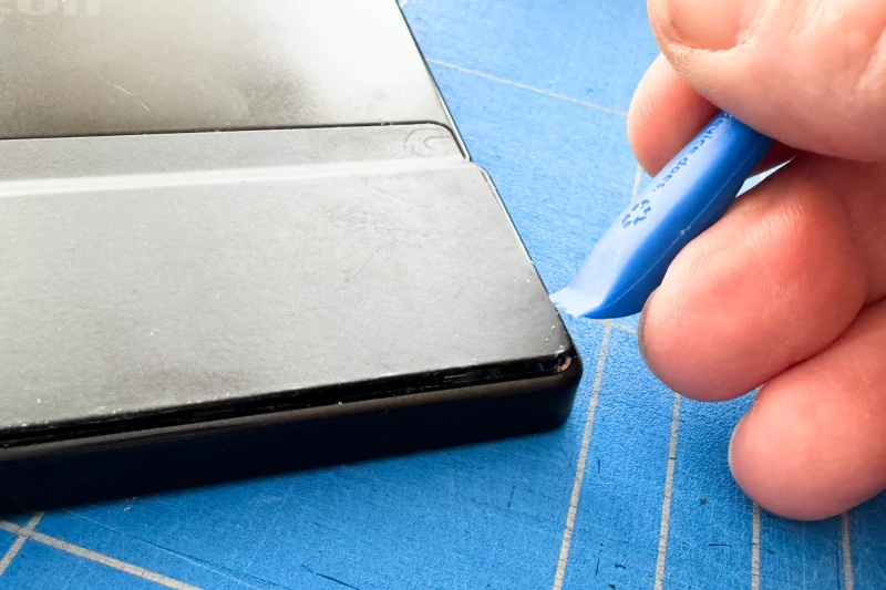 Wedging the tool in to unclip the back cover