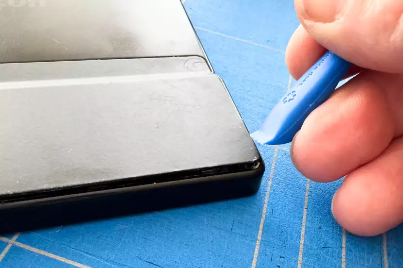 Wedging the tool in to unclip the back cover