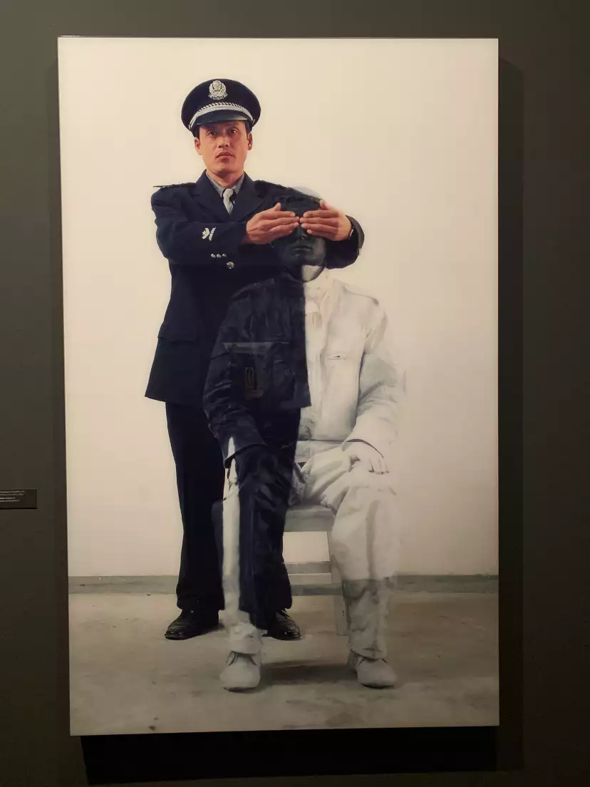 A police officer masking Liu Bolin's eyes