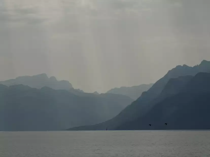 Blue and gray mountains over the lake in Hodler style