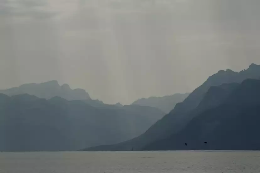 Blue and gray mountains over the lake in Hodler style
