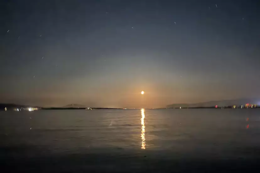 A golden moon setting on the lake at 1am