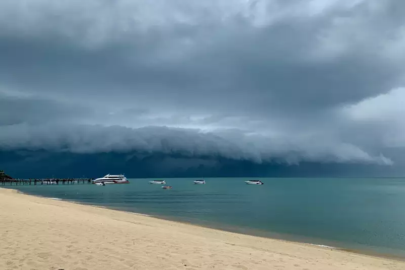 Dark skies over a golden beach. A storm is approaching.