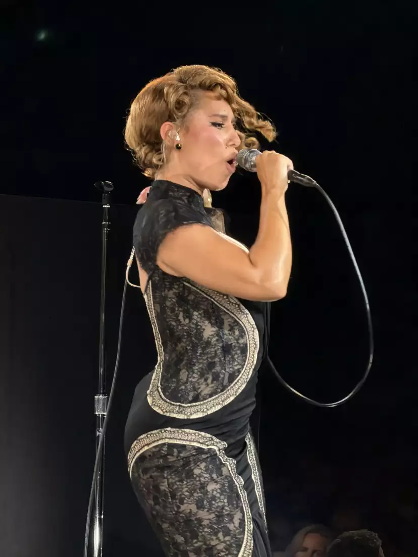 Close-up on RAYE holding her mic