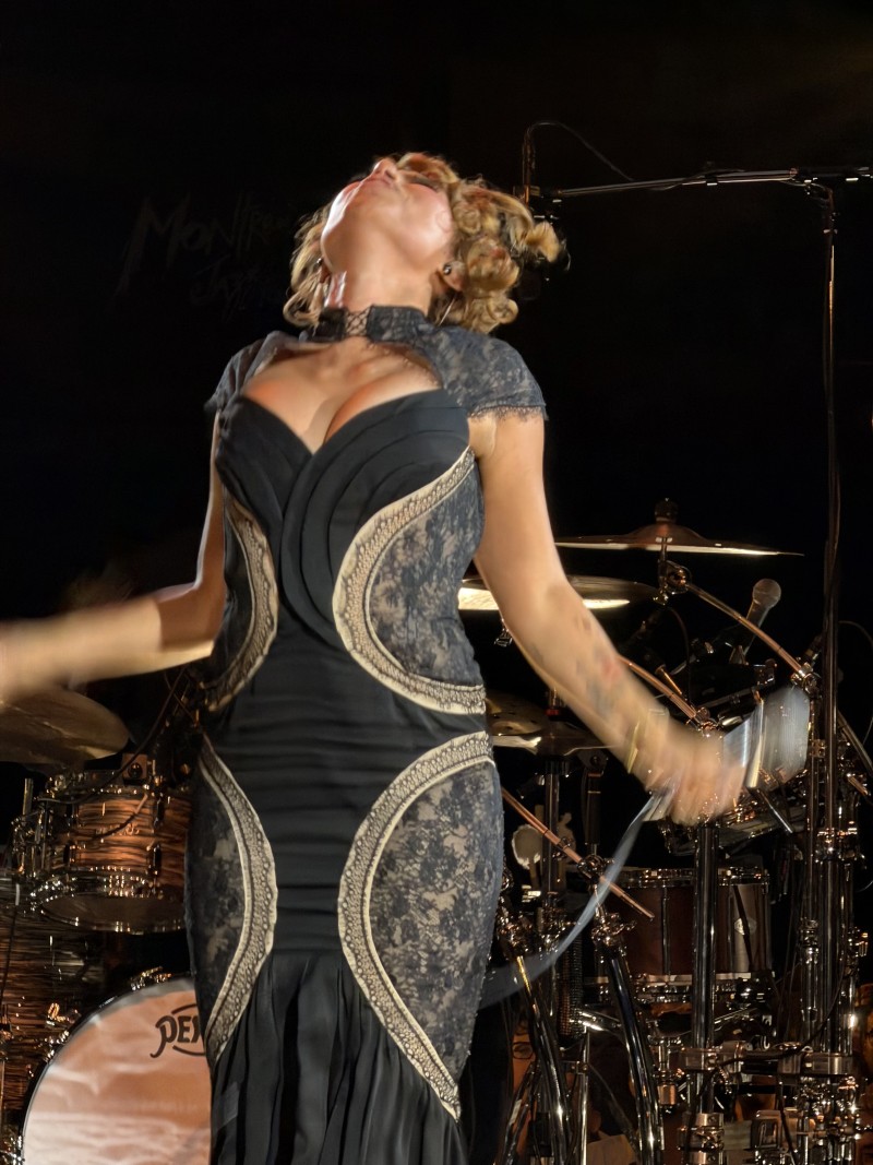 Close-up on RAYE holding her mic