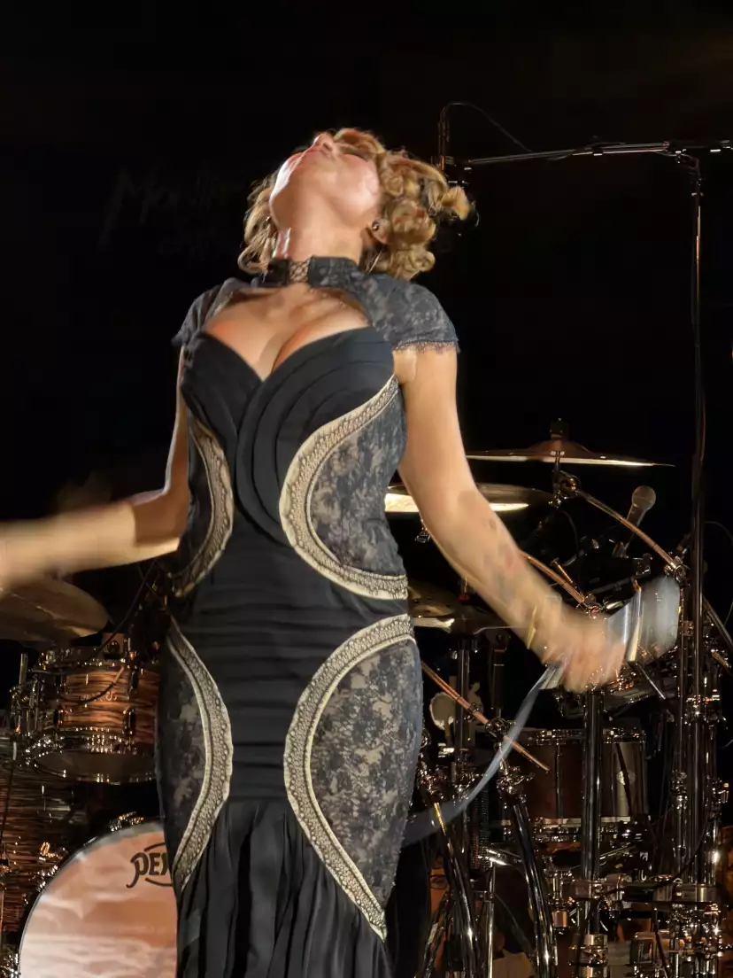 Close-up on RAYE holding her mic