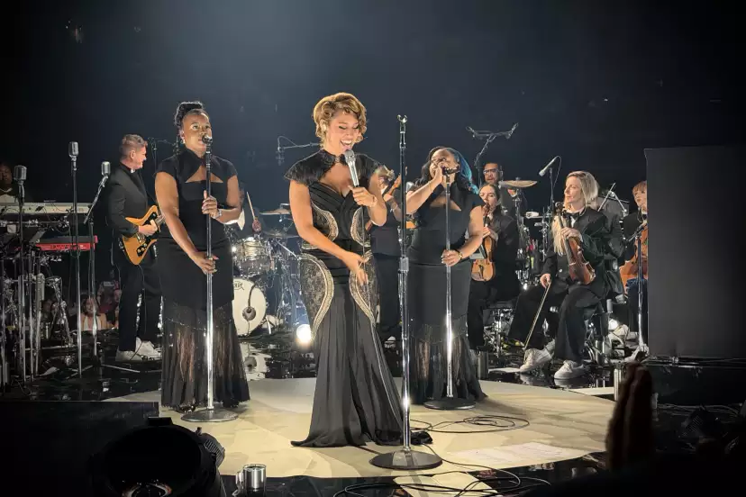 Front view of the set with RAYE in the middle, back vocals, lead guitar and strings behind
