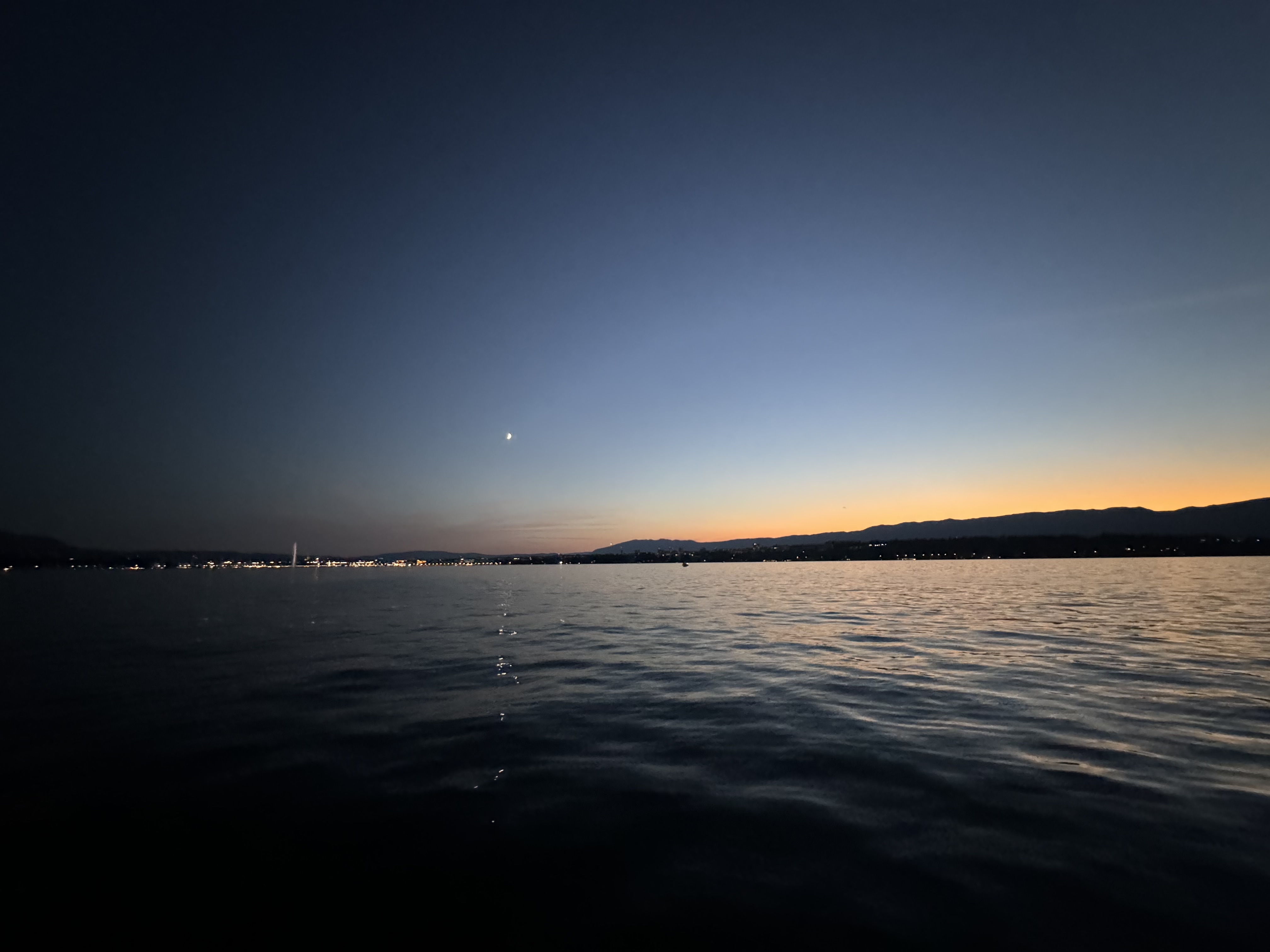 Dusk setting in on Geneva harbour. There's still light over the Jura to the West, the moon is out and all is quiet