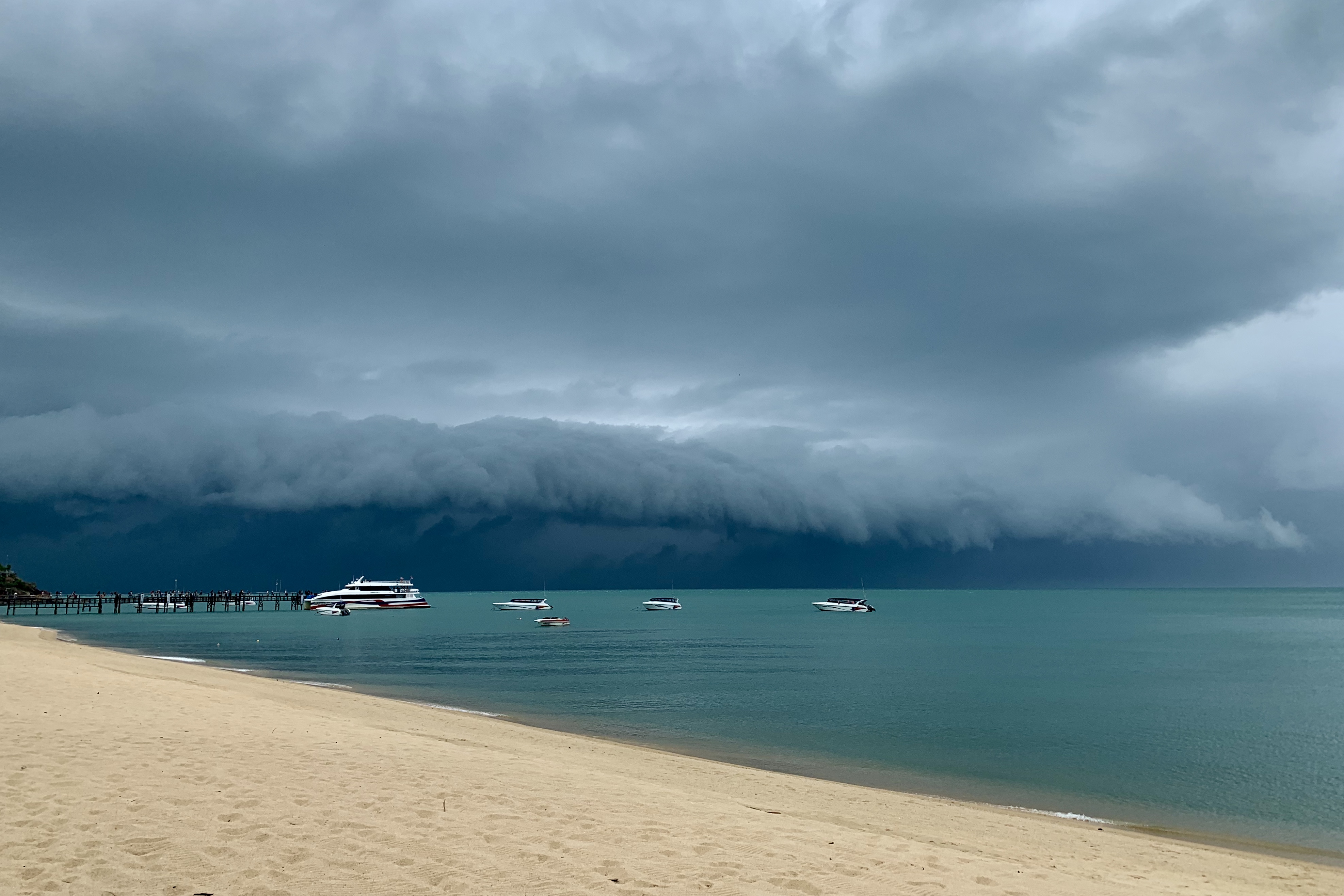 Dark skies over a golden beach. A storm is approaching.