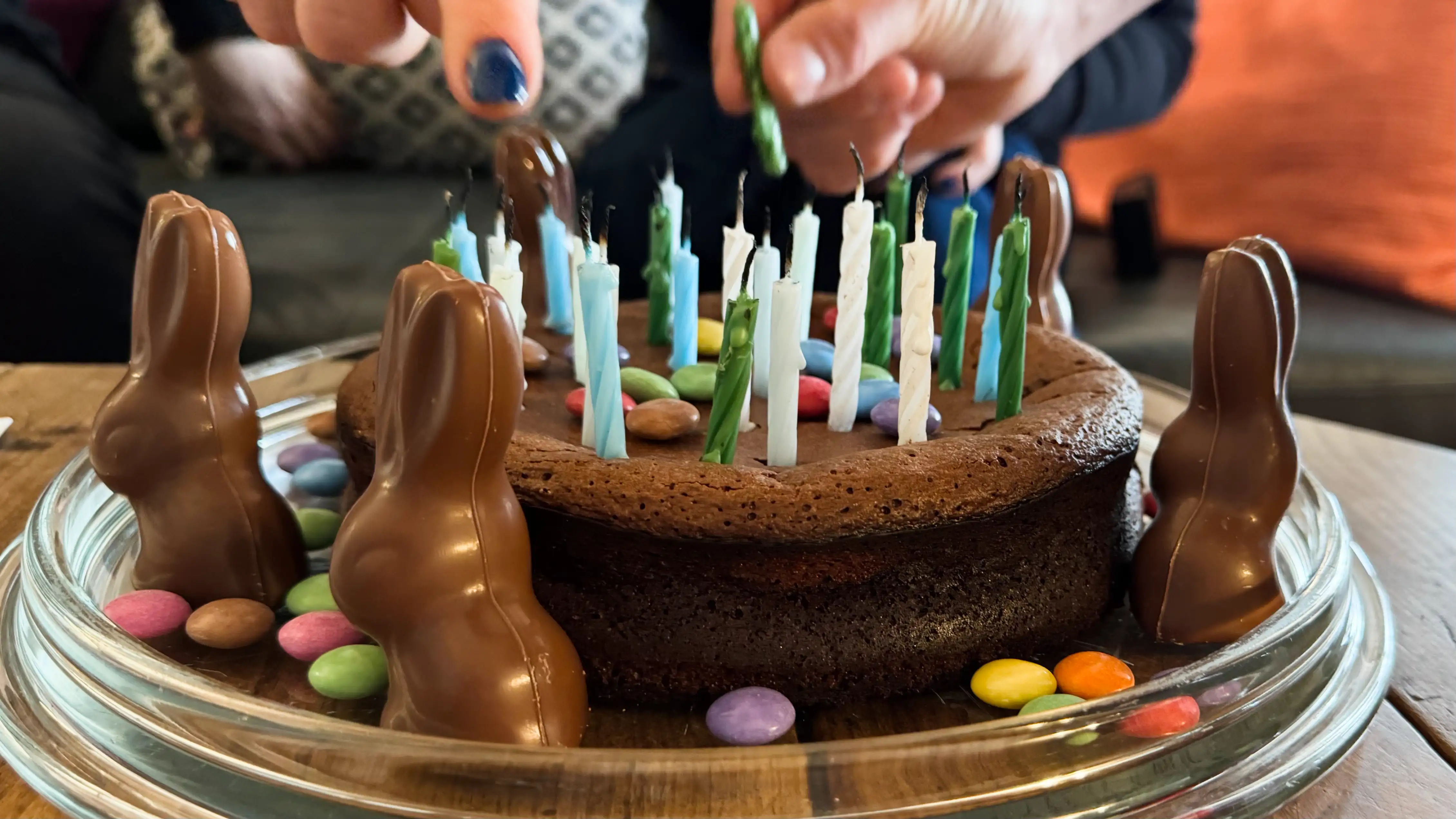 Chocolate cake with candles surrounded by chocolate Easter bunny rabbits